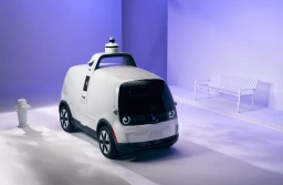 A white, four-wheeled, autonomous delivery robot by Nuro.